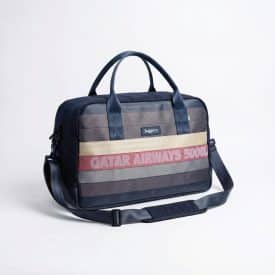 A large weekender bag made with upcycled cargo belts of different colors