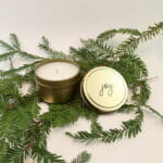 One of our gold tin candles bulk with a pine branch