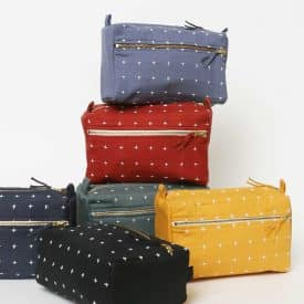 cross stitch toiletry bag mustard group Mustard group cross-stitch toiletry bags stacked vertically, showcasing assorted colors