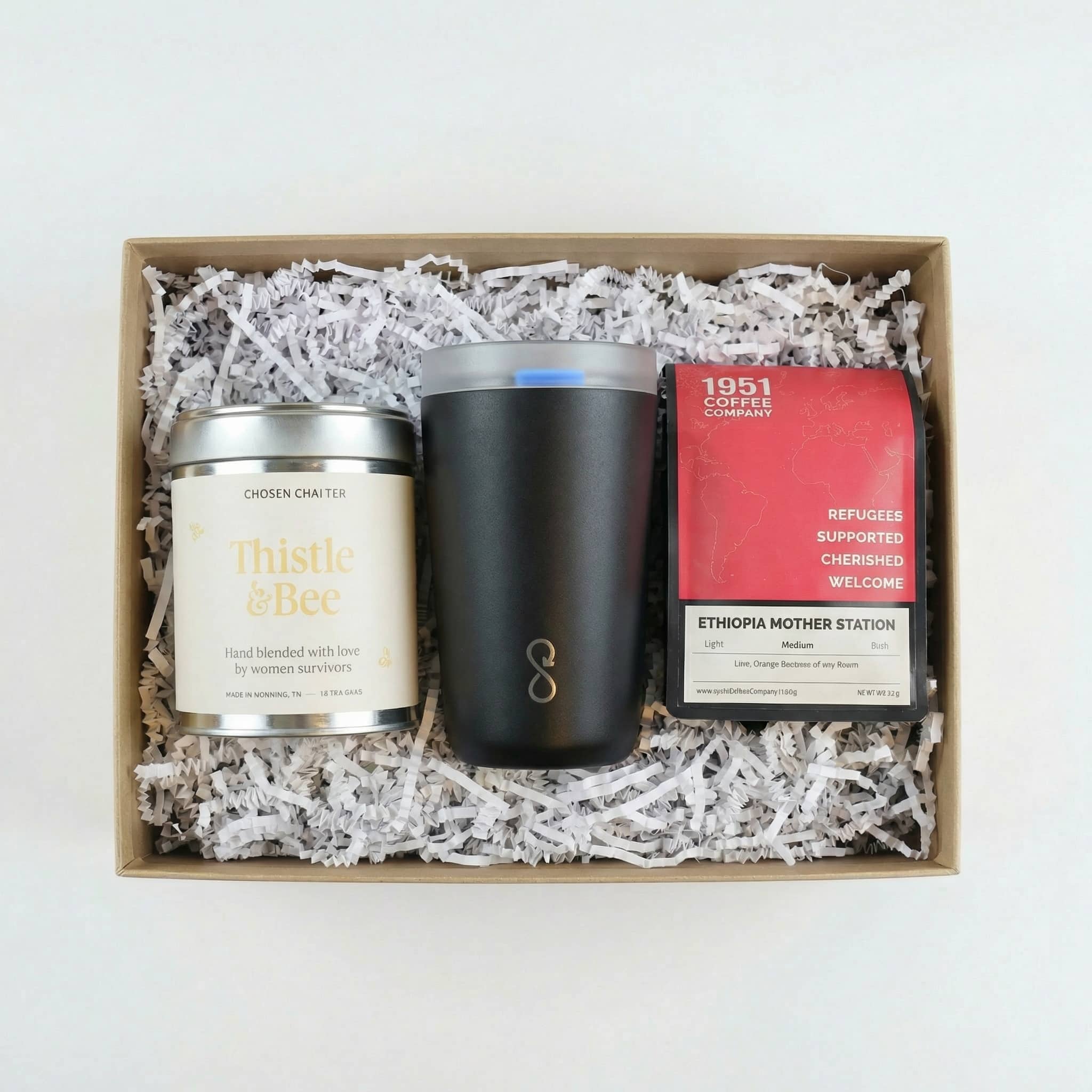 Fill Your Cup Gift Box white background A gift box with tea, coffee, and a tumbler nextled in white crinkle paper. A unique corporate gift.