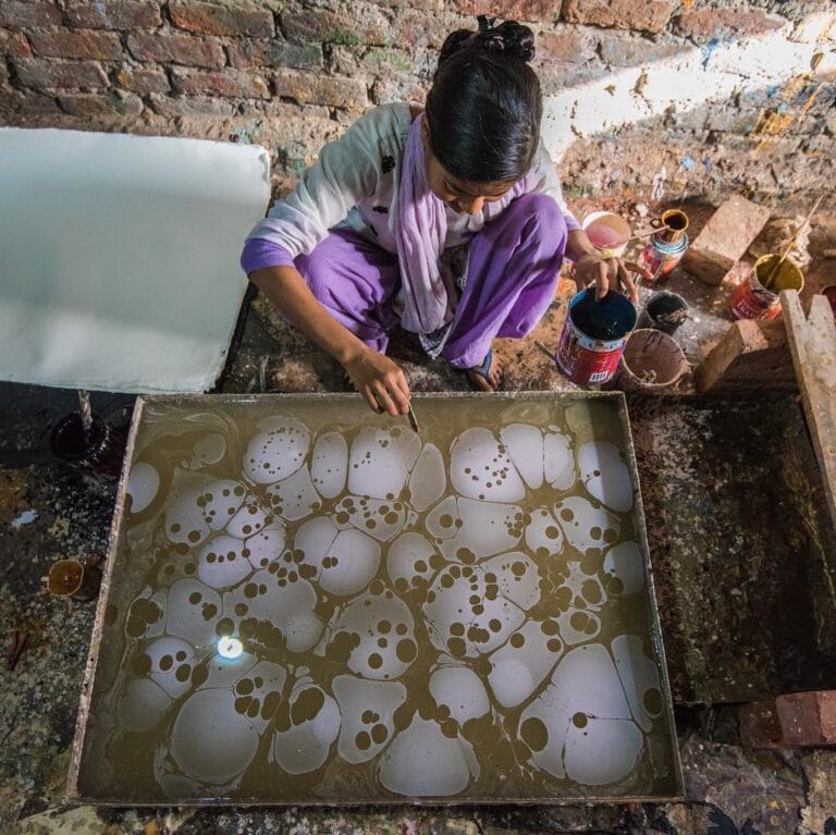 woman creating artwork for handmade notebooks