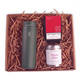 green tumbler with bag of coffee and tin tea