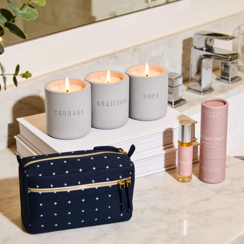 International Women's Day Gifts of candles, a blue toiletries bag, and an essential oil roll on