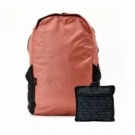 swathi packable backpack mauve a pink backpack that folds into a pouch inscribed with the names of the women survivors who made the bag