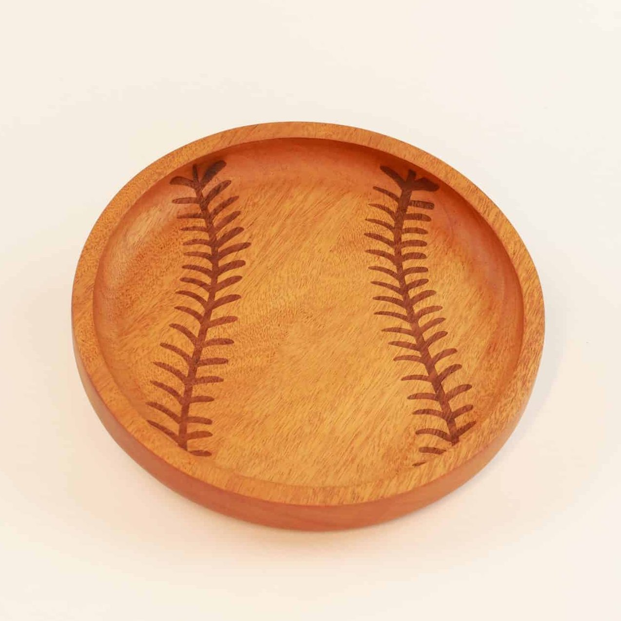 Itza Wood Baseball Tray a wooden tray engraved to look like a baseball is propped up slightly against a white background