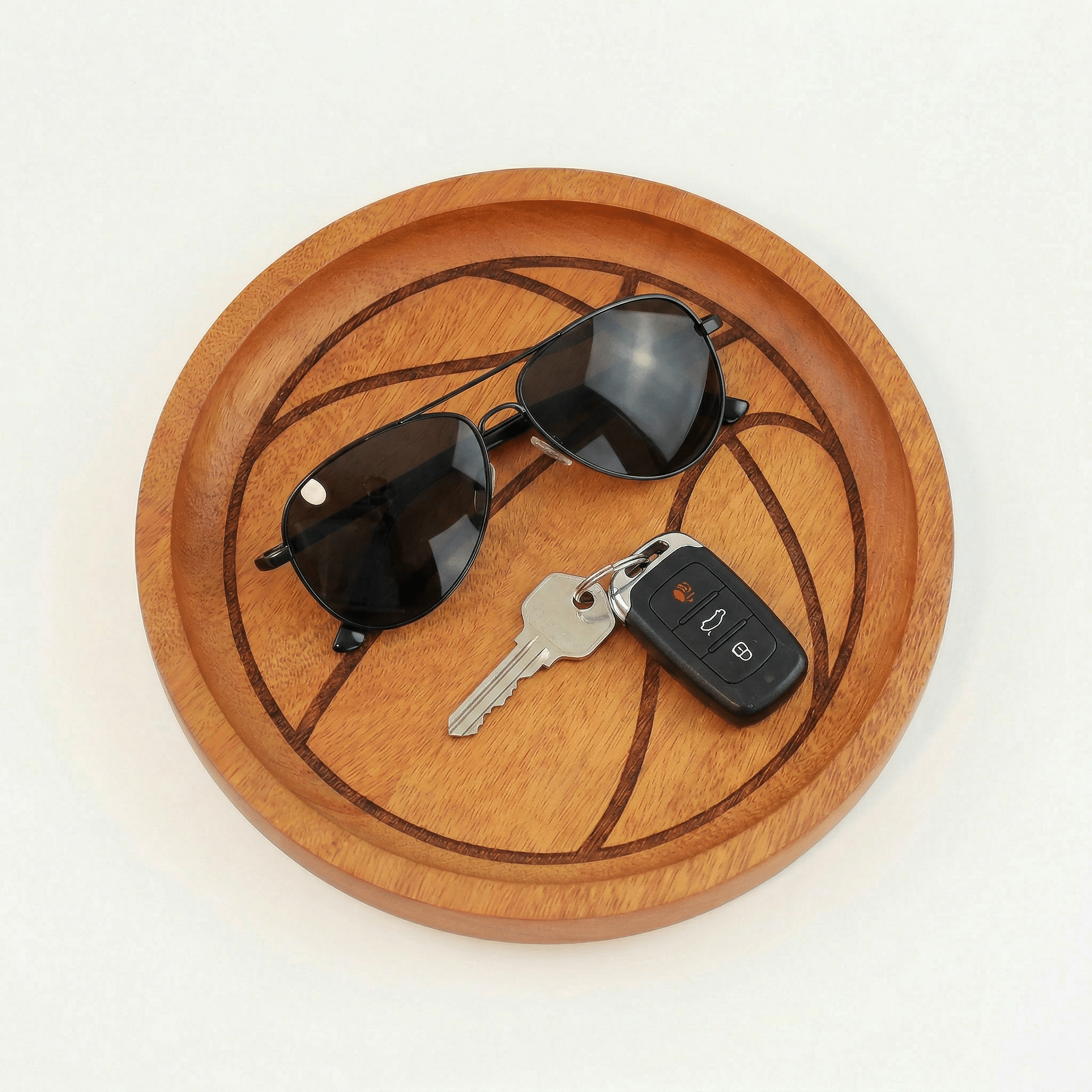 Itza Wood basketball tray a wooden tray with an engraving to make it look like a basketball. a pair of sunglasses and set of keys sit on top